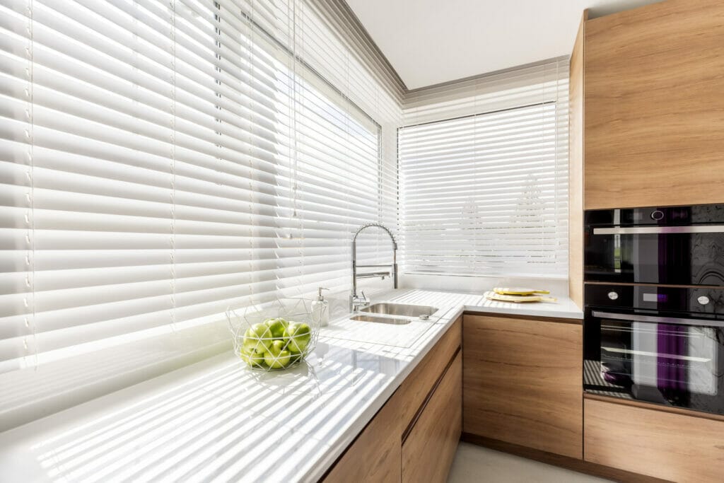A kitchen with white cleaned blinds