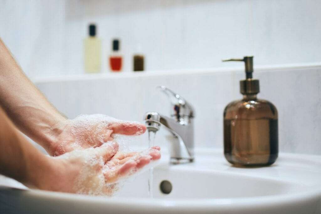 Person washing hands in the bathroom.