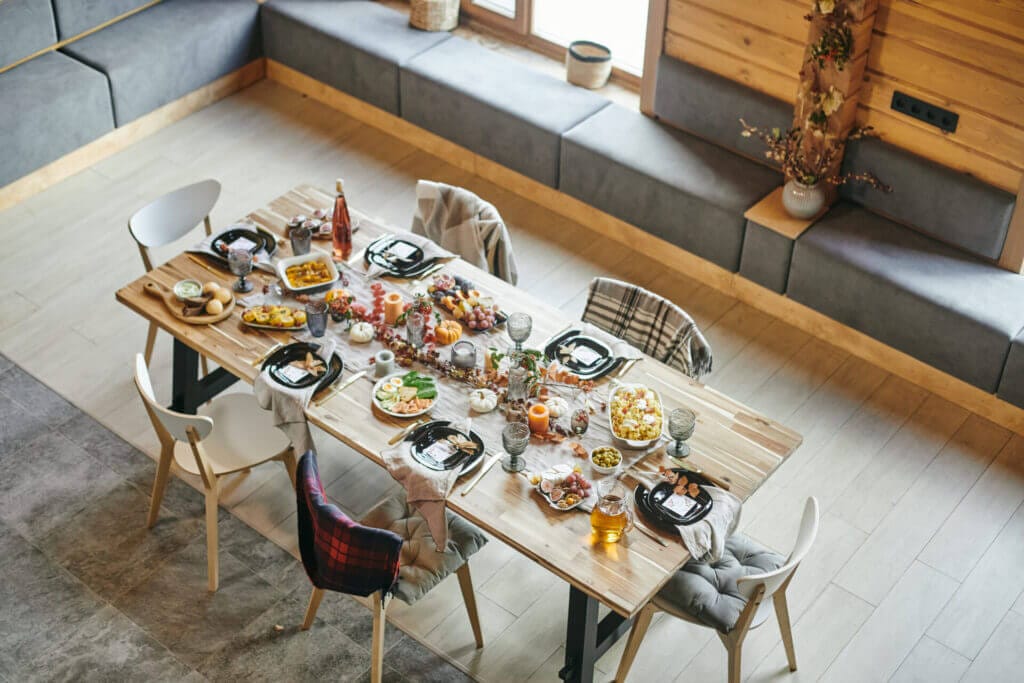 A large table with food and beautiful upholstered chairs.