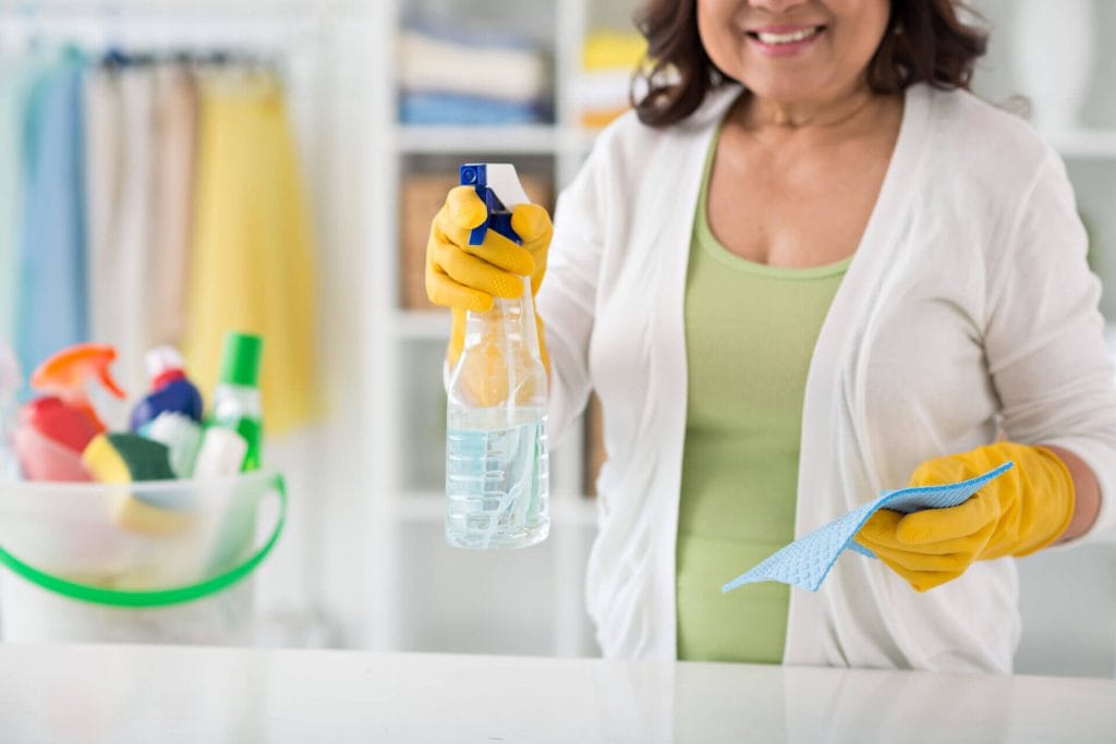 Woman with cleaning products showing how to clean fast and efficiently