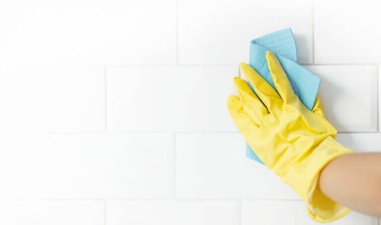 hand of a person cleaning his tiles after learning how to remove grout