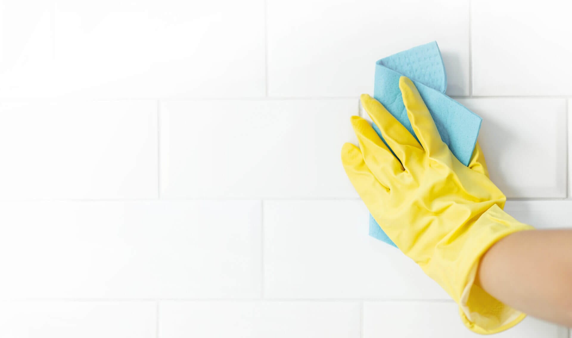 hand of a person cleaning his tiles after learning how to remove grout