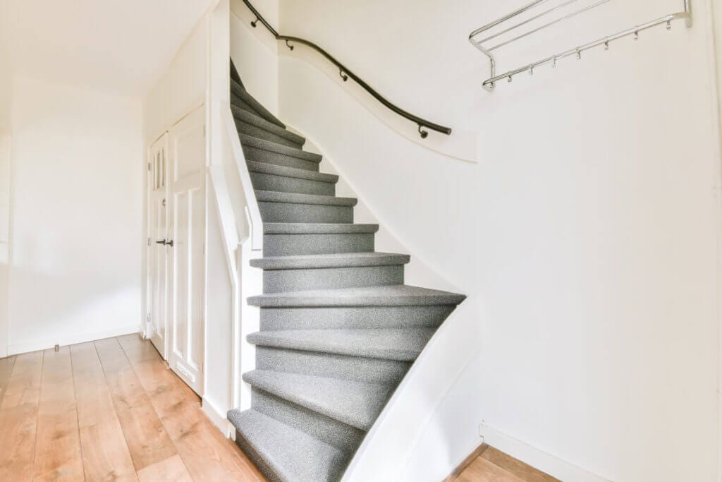 Beautiful spiral staircase with a gray carpet on it