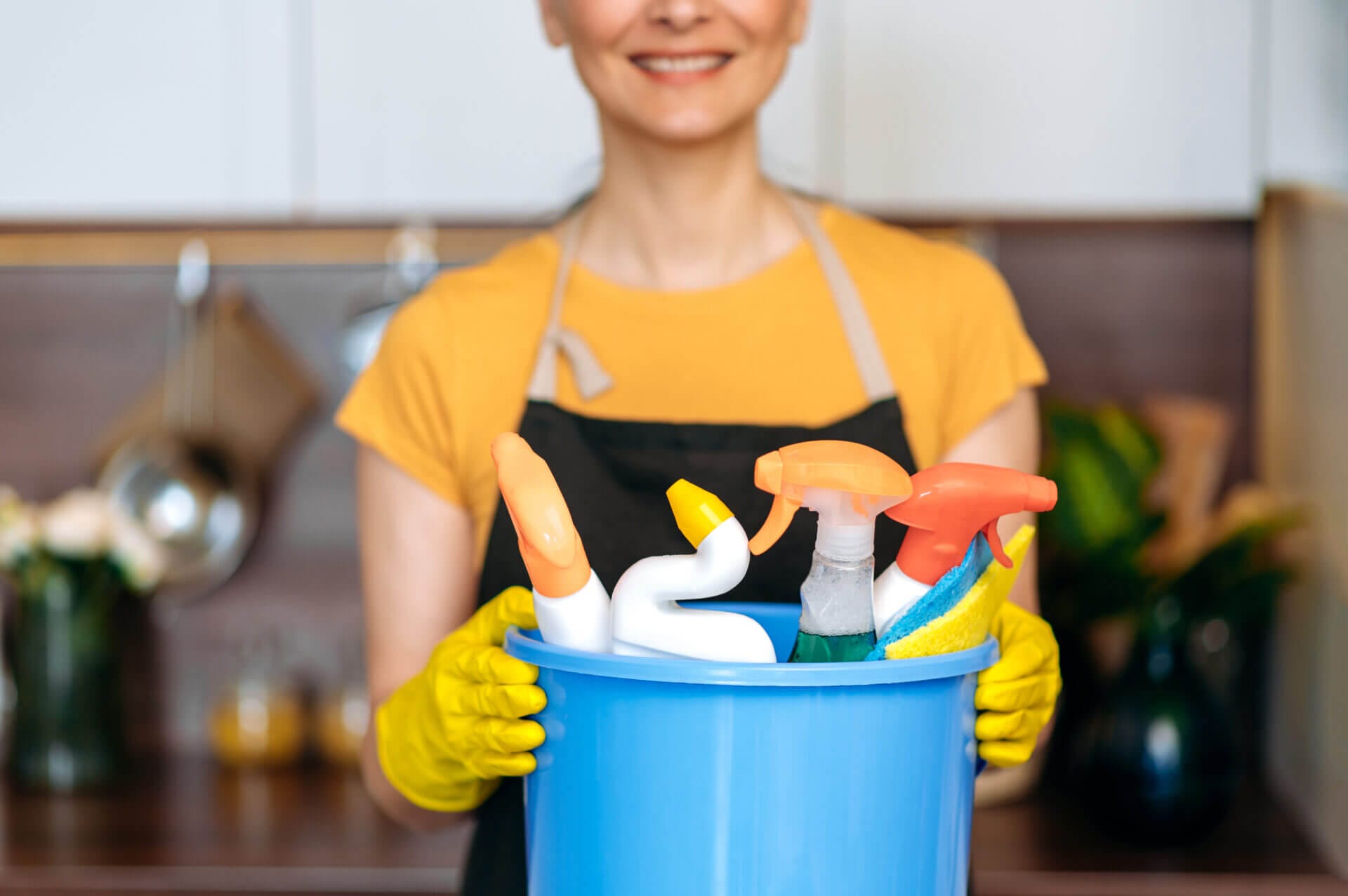 Cleaning service woman with a bucket of products ready to start cleaning showing the benefits of hiring a cleaning service