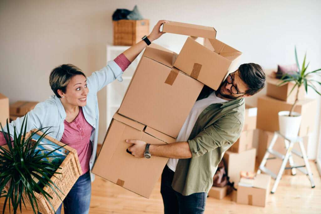 A couple moving boxes around their house to move out