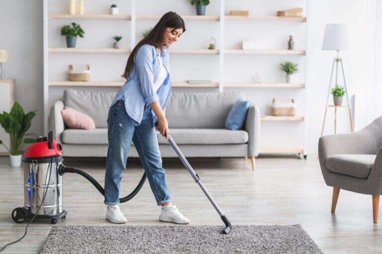 A person vacuuming their Persian rug after learning how to clean oriental rugs