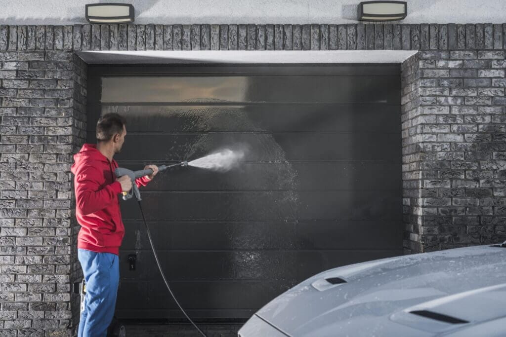 A person cleaning out the garage after learning how to clean garage walls