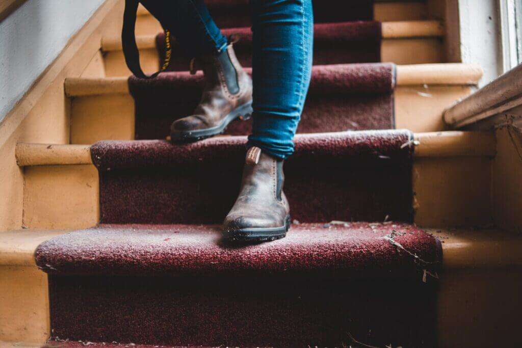 A person going down the stairs knowing how to deep clean carpet without machine